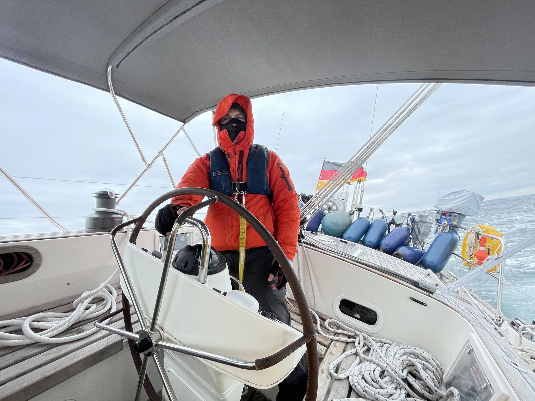 Felix at the helm in foul weather gear during his first offshore delivery